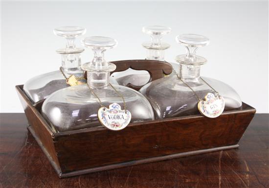 A set of four shaped glass decanters and stoppers, with an oak carrier 19th century, Continental, 35.5cm